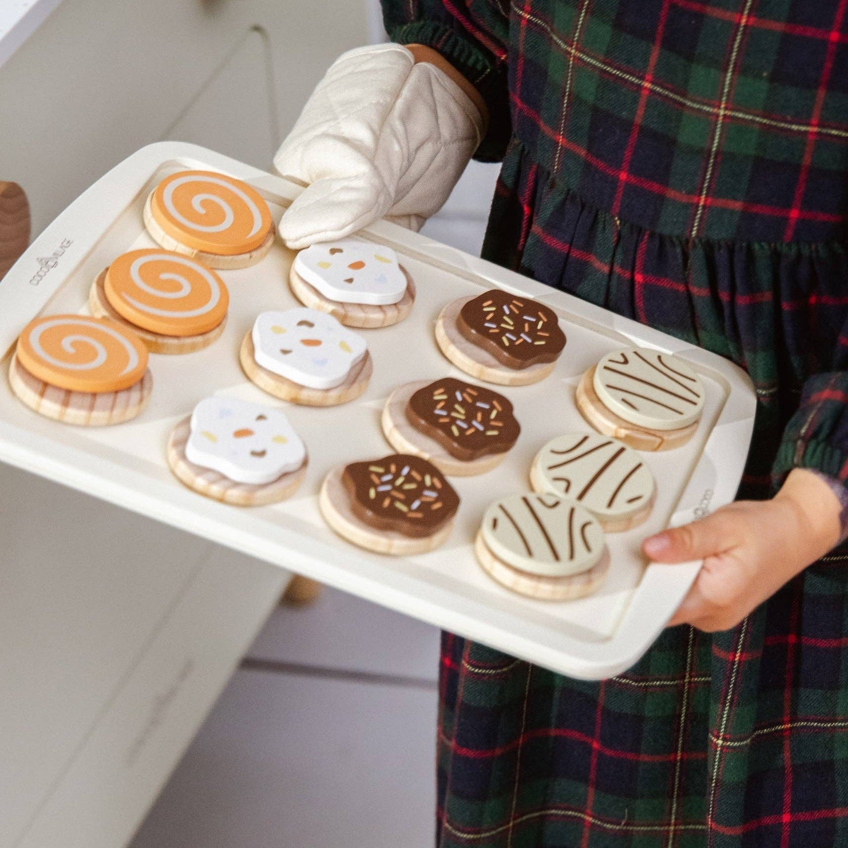 Kind met een bakplaat vol houten koekjes