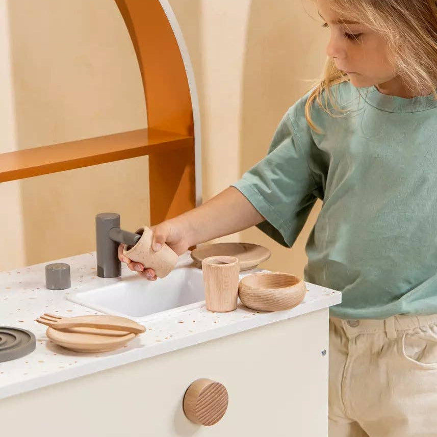 Kind speelt met de houten terrazzo kinderkeuken van Coco Village
